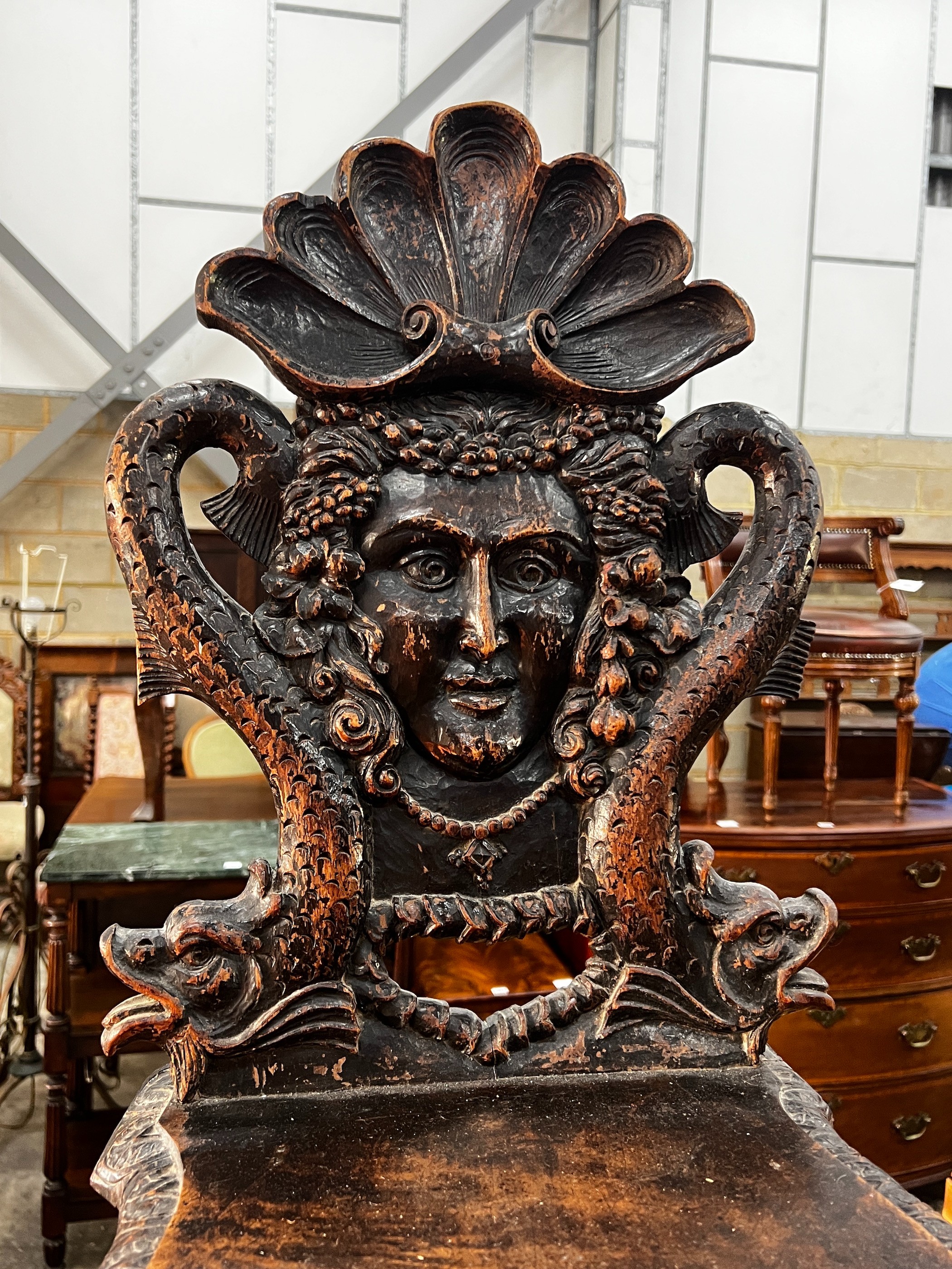 A 19th century Tyrolean oak hall chair, the back carved with a mask, a shell and serpents, height 94cm